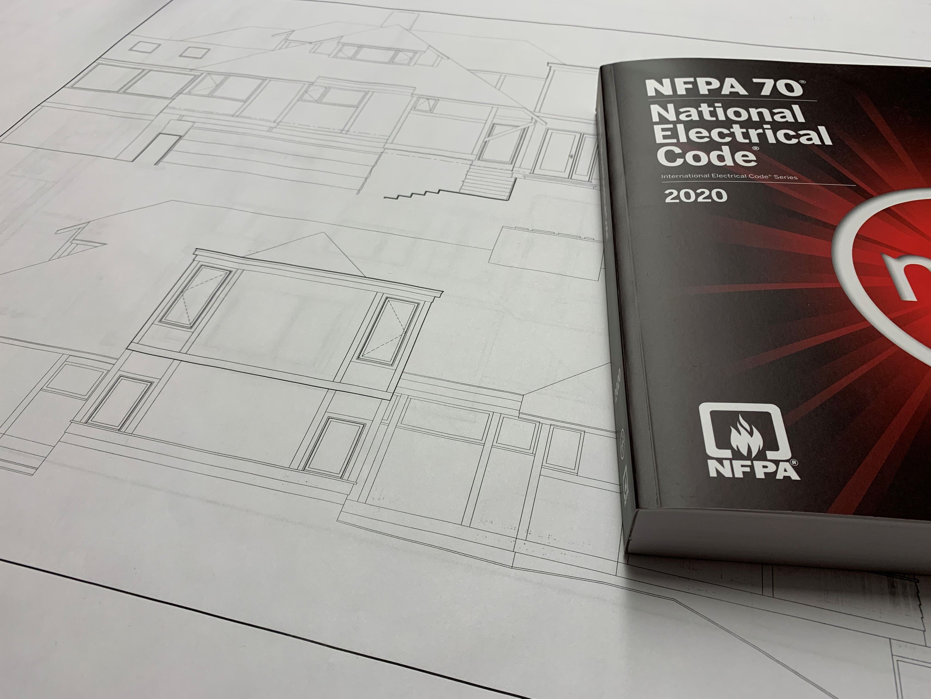 House blue prints with a 2020 electrician training manual laying on top.